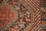 Close-up of geometric animal and bird motifs in madder root red, sky blue, and charcoal.