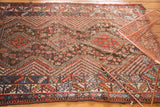 Vintage Qashqai rug's lower border with red, blue tribal patterns and worn fringe.