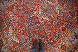 Cherry red ground and geometric patterns in brilliant blues on a vintage Heriz carpet.