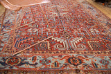 Hand-knotted vintage Heriz carpet's cherry red geometric field and light blue border.
