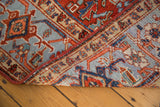 Hand-knotted Heriz carpet corner revealing woven structure, pile, and binding.