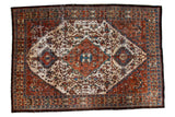 Vintage Baktiari carpet with copper diamond medallion, ivory scrolling vines, and even distress.
