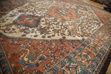 Baktiari rug's ivory field and scrolling vines with even distress to copper border.