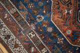 Detail of vintage Qashqai rug: deep blue and madder red field with intricate floral motifs.