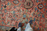 Blush, sky blue geometric Heriz carpet showing even wear and a happy palette underfoot.