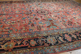 Heriz carpet border detail with geometric motifs in navy, blush, sky blue, and wine red.