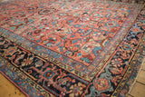 Vintage Heriz carpet edge showing navy blue geometric floral border and fringe.
