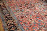 Hand-knotted Heriz rug detail displaying geometric floral renderings in blush, sky blue, and navy.