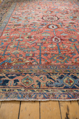 Blush, sky blue, and navy geometric floral border and fringe of a Vintage Heriz rug.