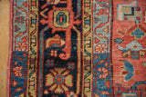 Blush side binding, geometric patterns in sky blue, navy, and beige on vintage Heriz pile.