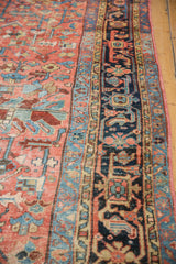 Traditional geometric blush field and layered navy, sky blue borders on a vintage Heriz carpet, even wear.