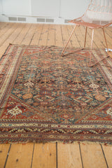 Tattered ends and geometric border with madder root red and sky blue motifs on an antique Qashqai rug.