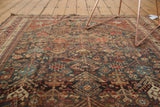 Intricate field pattern of germinating plants and pinwheel motifs in madder red and dark teal.