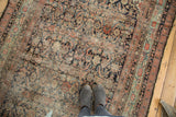 Antique Northwest runner with faded navy Herati pattern, low pile, and exposed foundation.