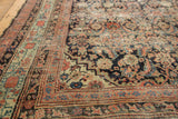 Detail of antique Northwest rug's complex border and time-softened navy, blush, green Herati pattern.
