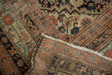 Folded antique Northwest Persian runner, Herati pattern, worn pile, softened blush, blue, sand, and fringe.