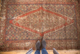 Distressed Antique Fereghan rug with exaggerated diamond medallion, madder red field, and aged patina.