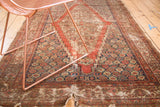 Distressed antique Feraghan rug showing vivid madder root red field and navy patterns with tatter.