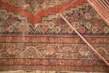 Geometric and floral borders of the Antique Fereghan rug, showing madder red and aged patina.