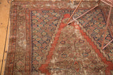Distressed Antique Feraghan rug section showing worn madder root red field, stepped navy motifs.