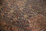 Vintage Mahal carpet's Herati motif with navy, rust, beige, and subtle green on even-worn pile.