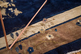 Peking style Chinese carpet detail with deep blue, ivory, beige floral and eucalyptus motifs.