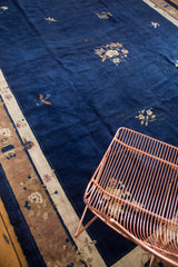 Late Peking style vintage carpet: cobalt blue field, scattered floral, cream, and brown border.