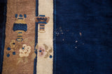Vintage Peking rug detail: cobalt blue field, cream border, floral vase motifs, and low pile texture.