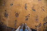 Vintage Peking carpet section with stylized golden-brown, navy, and cobalt motifs.