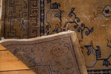 Folded vintage Peking rug corner reveals back, pile wear, secure fringe, and blue color migration.