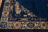 Vintage Peking rug corner with delicate vase and branch motifs on a cobalt blue field.