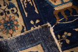 Vintage Peking carpet's indigo blue field, blush floral motifs, and hand-woven foundation.
