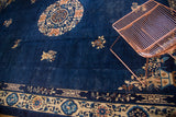 Vintage Peking carpet corner showcasing beige floral border, blue geometric guard, and indigo field.