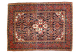 Vintage Dargezine rug, navy blue medallion, primitive floral motifs, brick red borders, even wear.