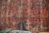 Vintage Lilihan rug displaying raspberry, blue, and gold floral bouquets with even distress.
