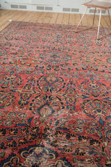 Vintage Lilihan rug's distressed raspberry red field, showing blue floral motifs and foundation.