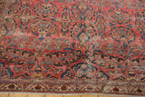 Distressed red field of a vintage Lilihan rug, showing floral bouquets and lower border.