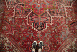 Vintage Mehrivan rug's bold red field, geometric medallion, florals, and visible foundation wear.