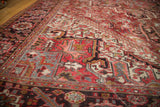 Angled close-up of vintage Mehrivan rug, showing geometric patterns in red, ivory, and blue.
