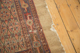 Hard tatter on vintage Hamadan rug's natural camel hair border with red and blue pattern.