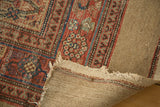 Folded corner of vintage runner, revealing tattered camel hair border and natural wool foundation.