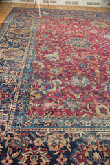 Intricate palmettes and tendrils on aged cochineal red field and navy border.
