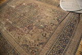 Distressed patina wine red and navy floral patterns on a vintage Persian Meshed rug.