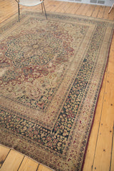 Vintage Meshed rug corner with ornate ivory floral border, distressed navy field, and secured red edge.