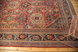 Mahalati rug corner: cherry red Herati field, vinery, and charcoal navy geometric border.