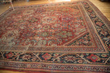 Traditional Mahalati rug with charcoal navy border and cherry red Herati and lotus patterns.