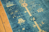 Antique Peking carpet edge, displaying ivory pictorial imagery on varied watery blue pile.