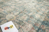 Distressed vintage Mahal rug pile, displaying faded aqua blue and cinnamon red Herati motifs.