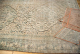 Distressed Northwest Persian carpet featuring faded ivory, apricot medallion, and exposed foundation.