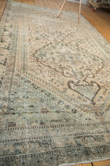 Distressed vintage Northwest Persian carpet showing even wear, visible foundation, muted patterns, and fringe.